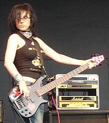 A member of the band plays her electric guitar